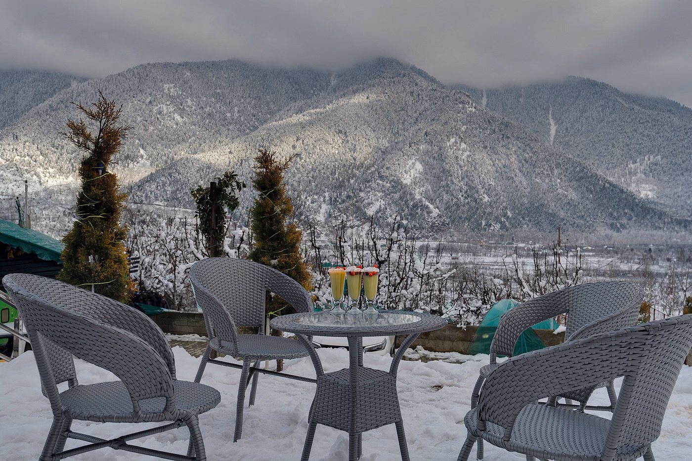 Terrace seating at Hotel Sparrow overlooking snow-dusted Himalayan mountains