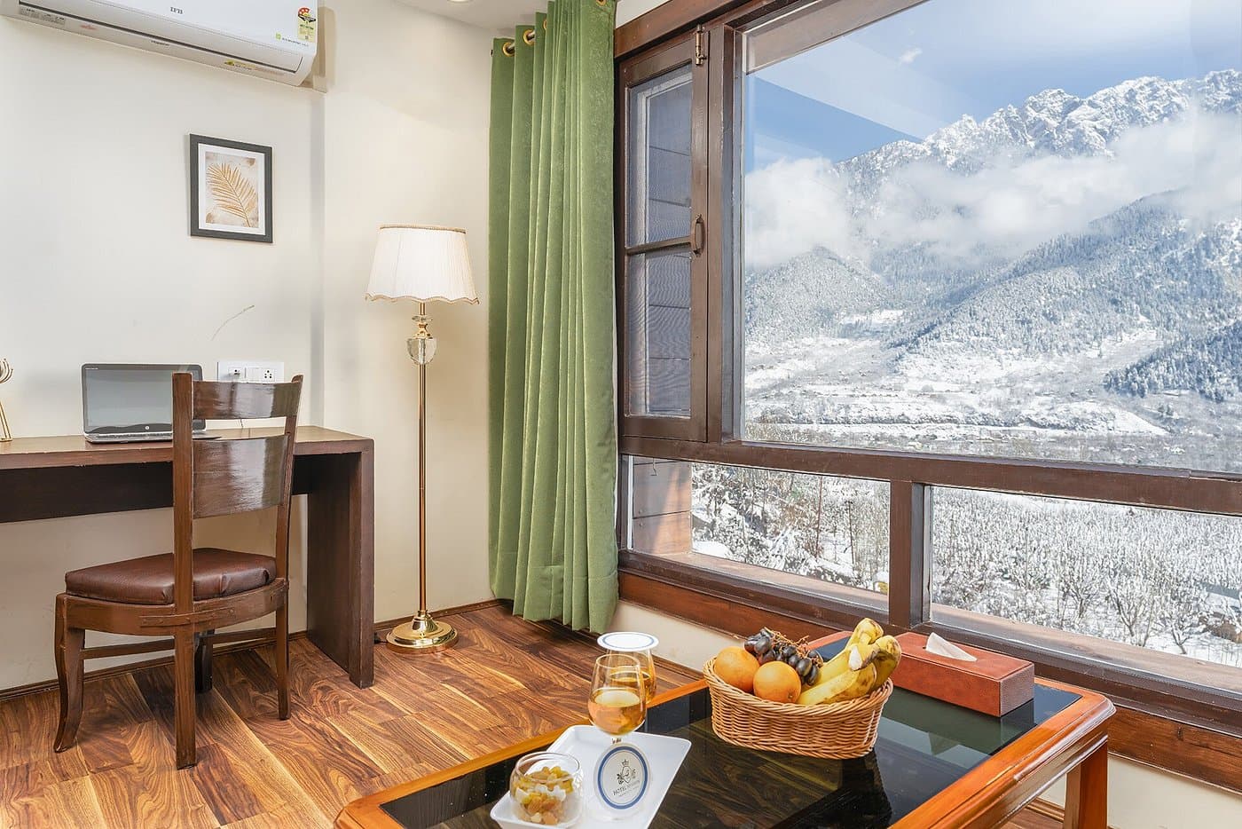 Room at Hotel Sparrow with a panoramic window overlooking snow-capped Himalayan peaks in Pahalgam