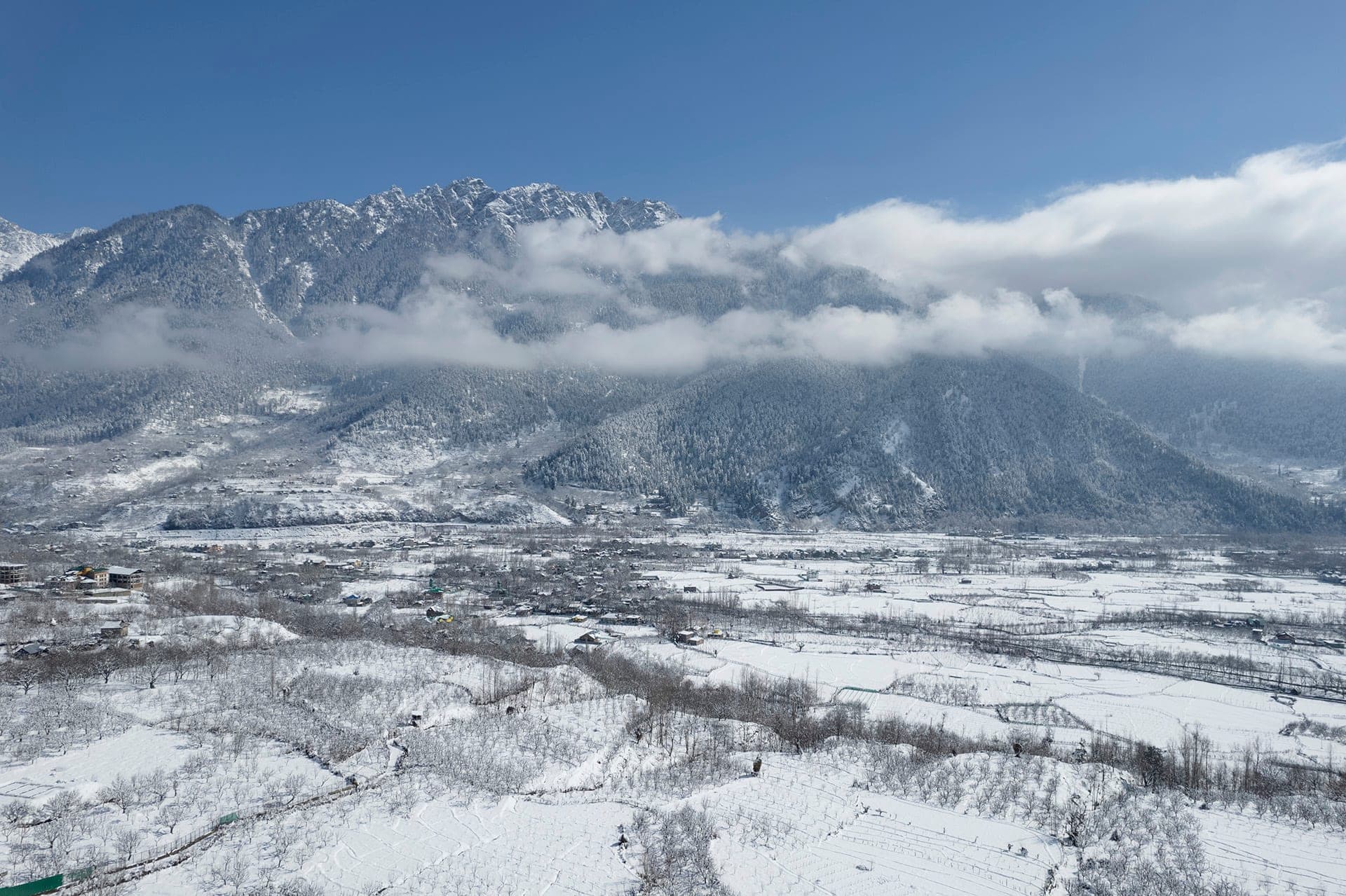 Wide view of the snow-covered Pahalgam valley beneath the Himalayan mountains