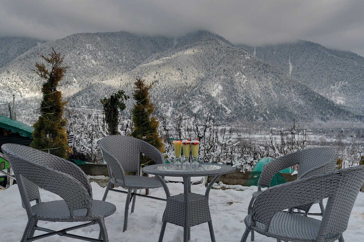 Terrace seating at Hotel Sparrow overlooking snow-dusted Himalayan mountains