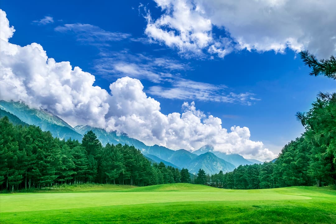 The green fairways of Pahalgam Golf Course ringed by pine forest and mountains The green fairways of Pahalgam Golf Course ringed by pine forest and mountains